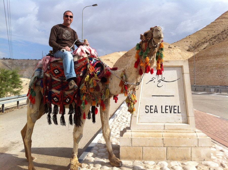 gids op kameel bij de dode zee